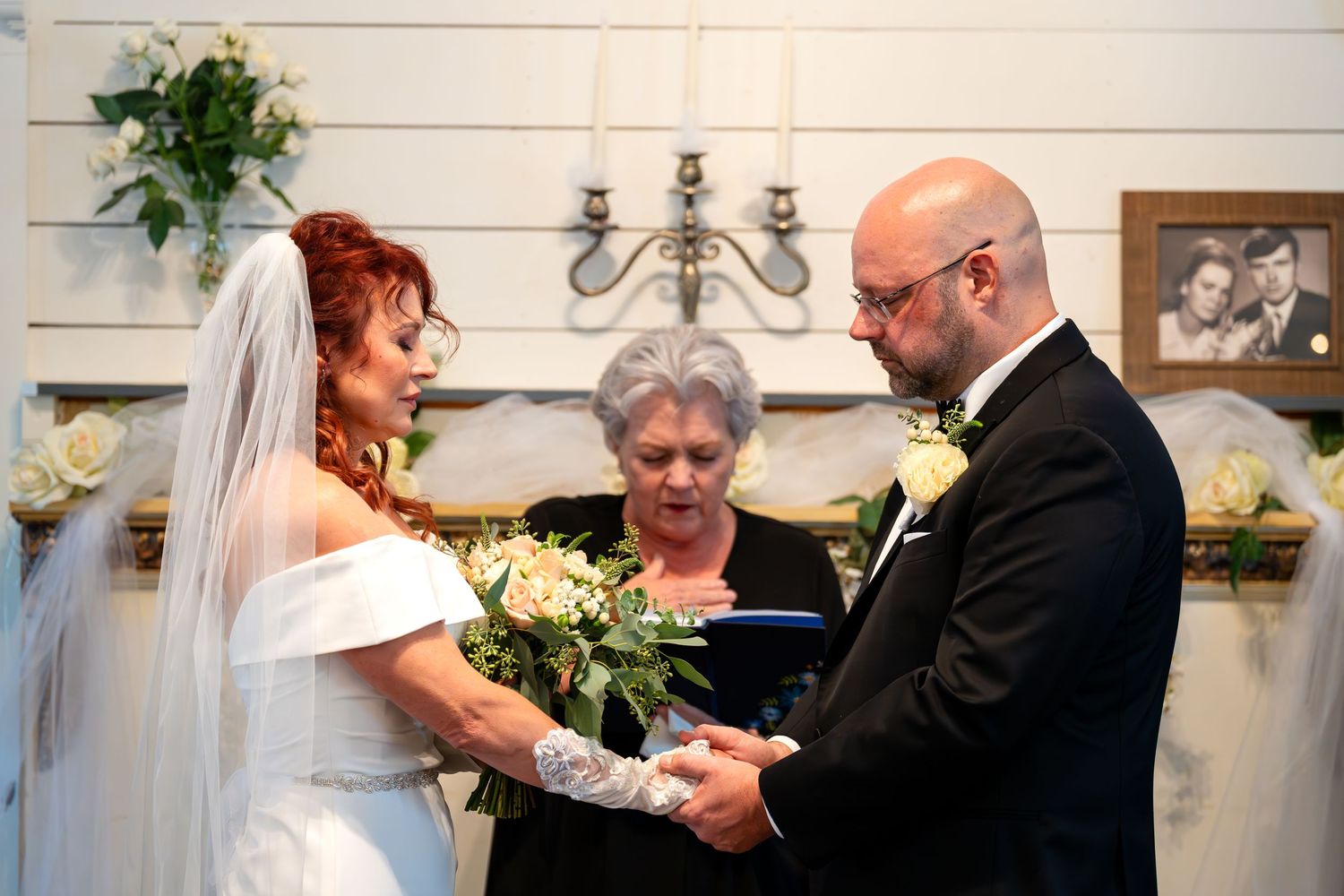 Intimate wedding ceremony with couple holding hands in front of officiant.