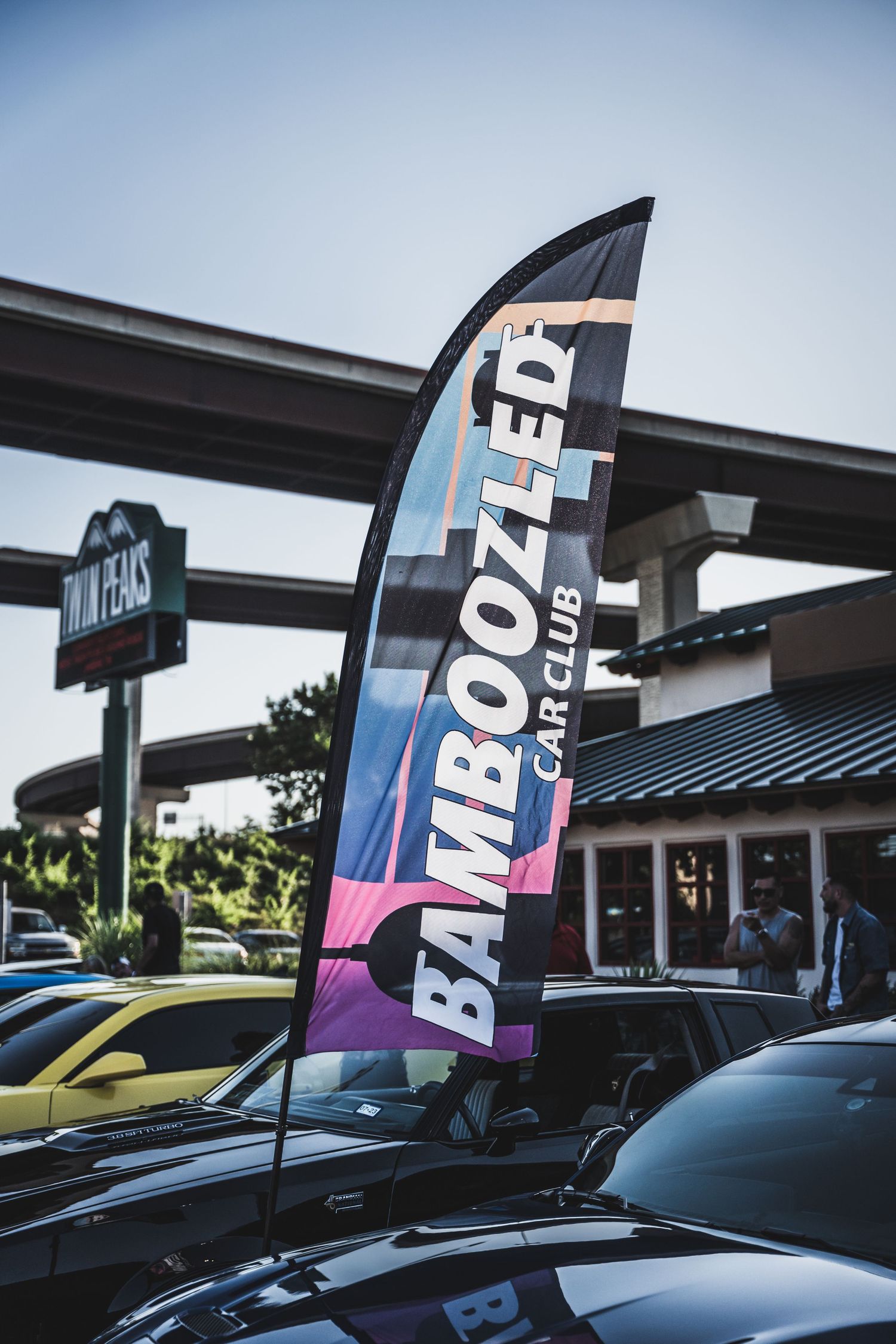 Bamboo Zed Car Club feather flag banner displayed at automotive event.