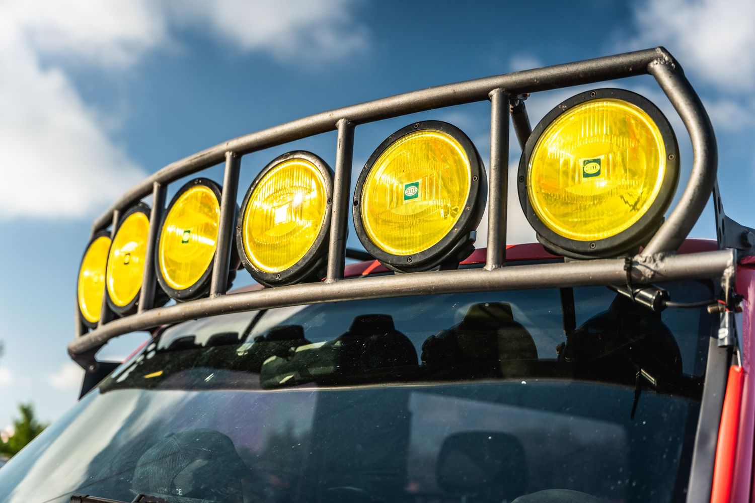 Row of yellow off-road lights mounted on vehicle roof rack.