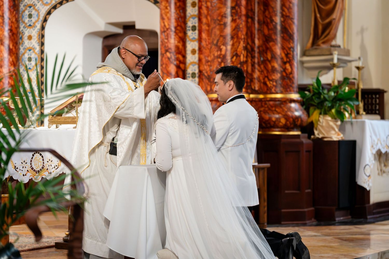 Religious ceremony taking place at an ornate altar with white robes and traditional church decor.