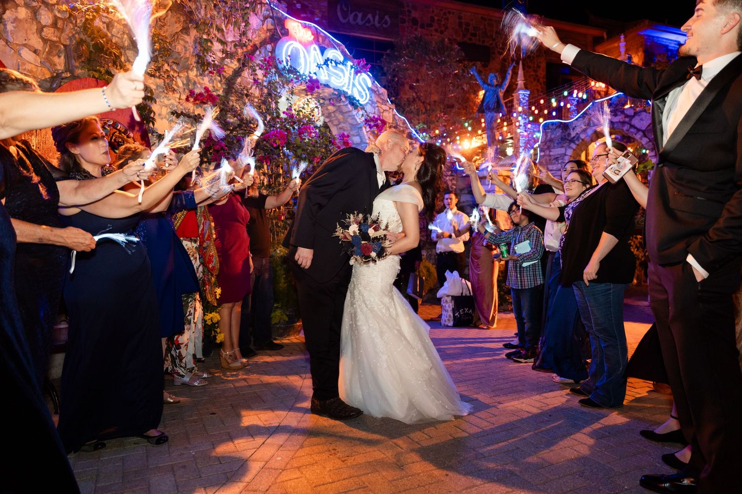 A couple walks through a sparkler exit tunnel during their wedding reception celebration.