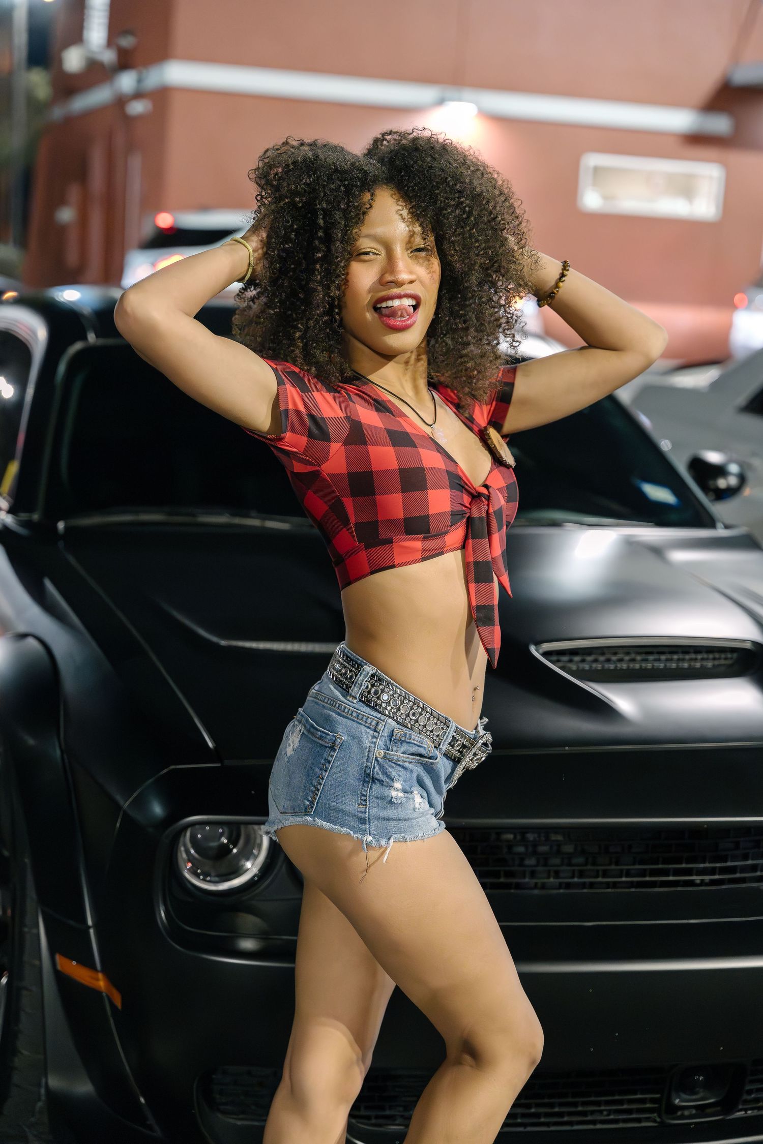 Car meet scene with classic muscle car in background at night.