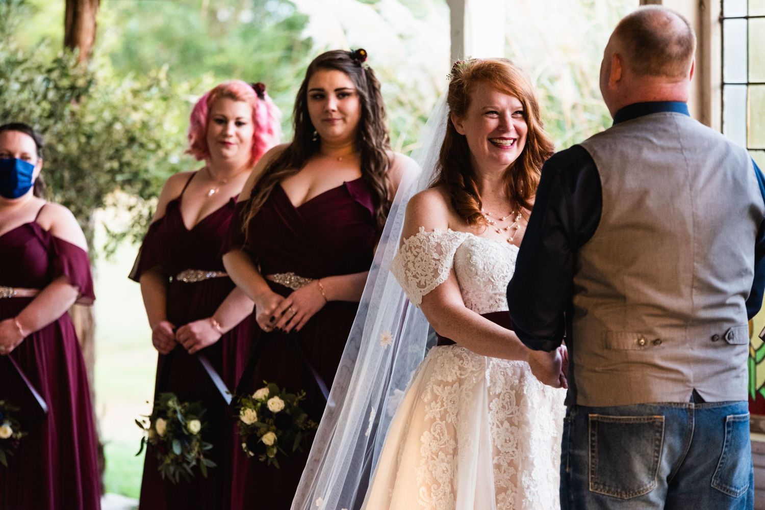 Wedding party smiles and laughs during a light-hearted ceremony moment.