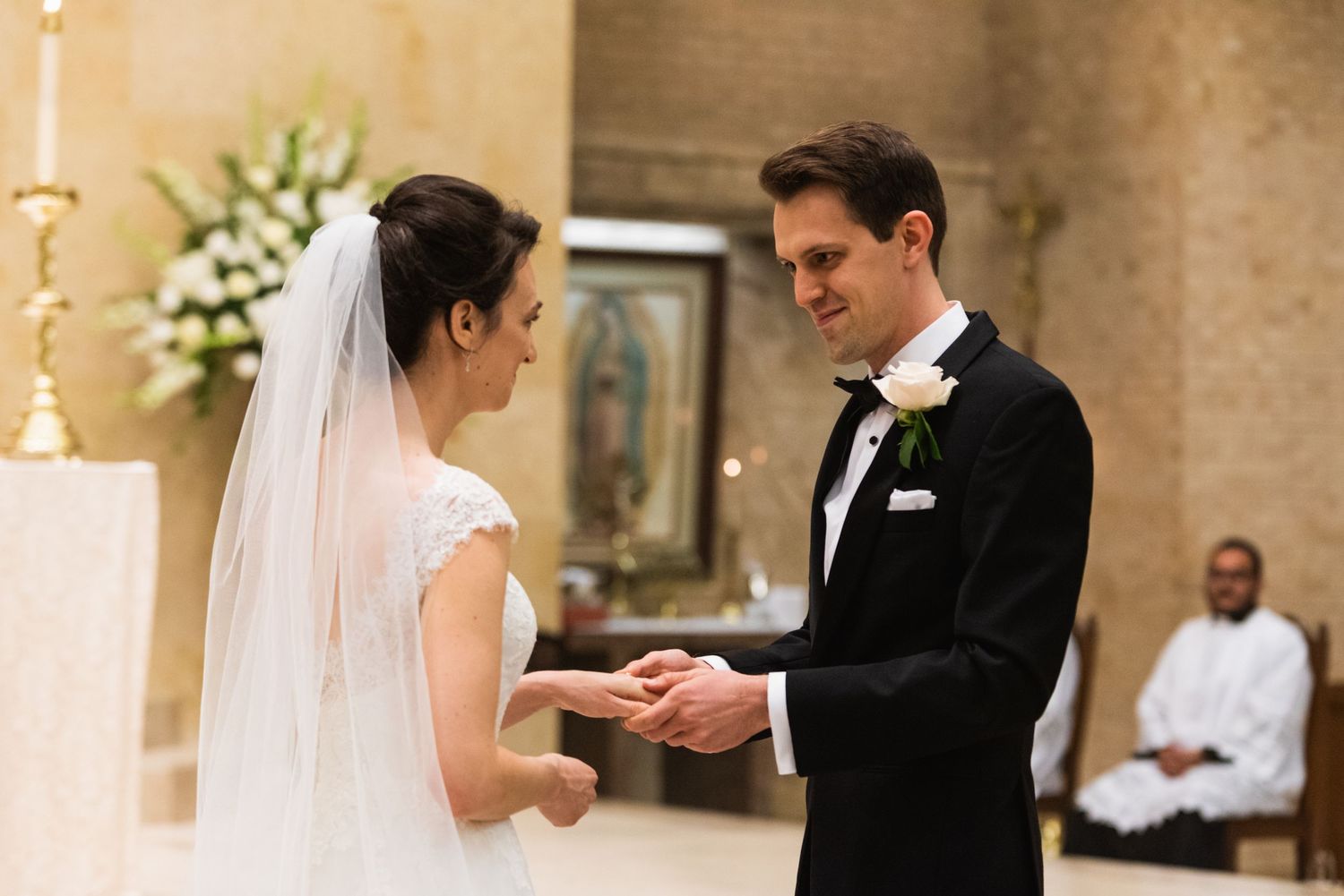 Romantic ring exchange moment between bride and groom during wedding ceremony.