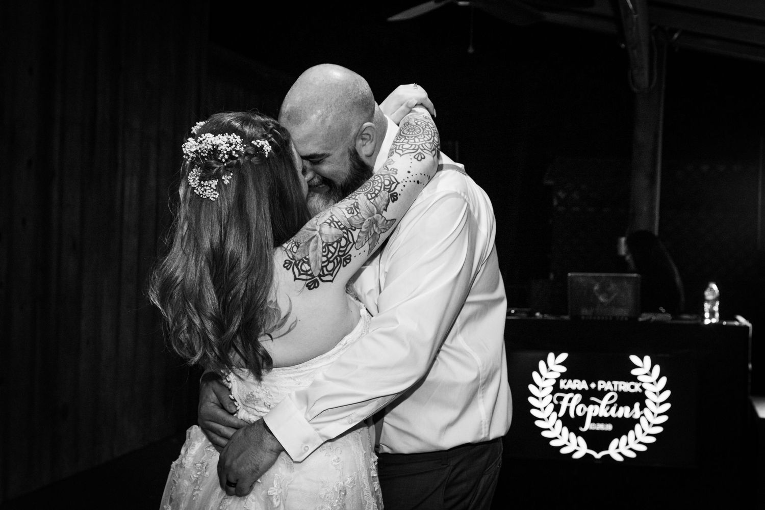 Black and white portrait of a tender embrace during wedding celebration.