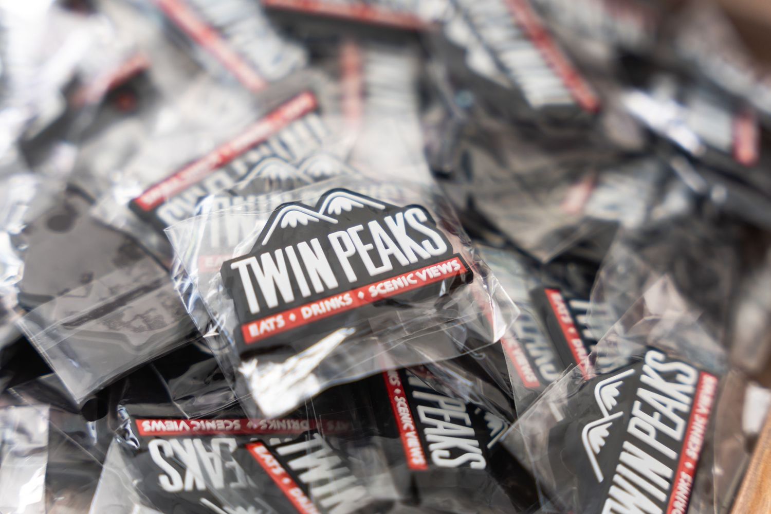 Multiple packets of Twin Peaks branded merchandise shown in a blurred close-up shot.