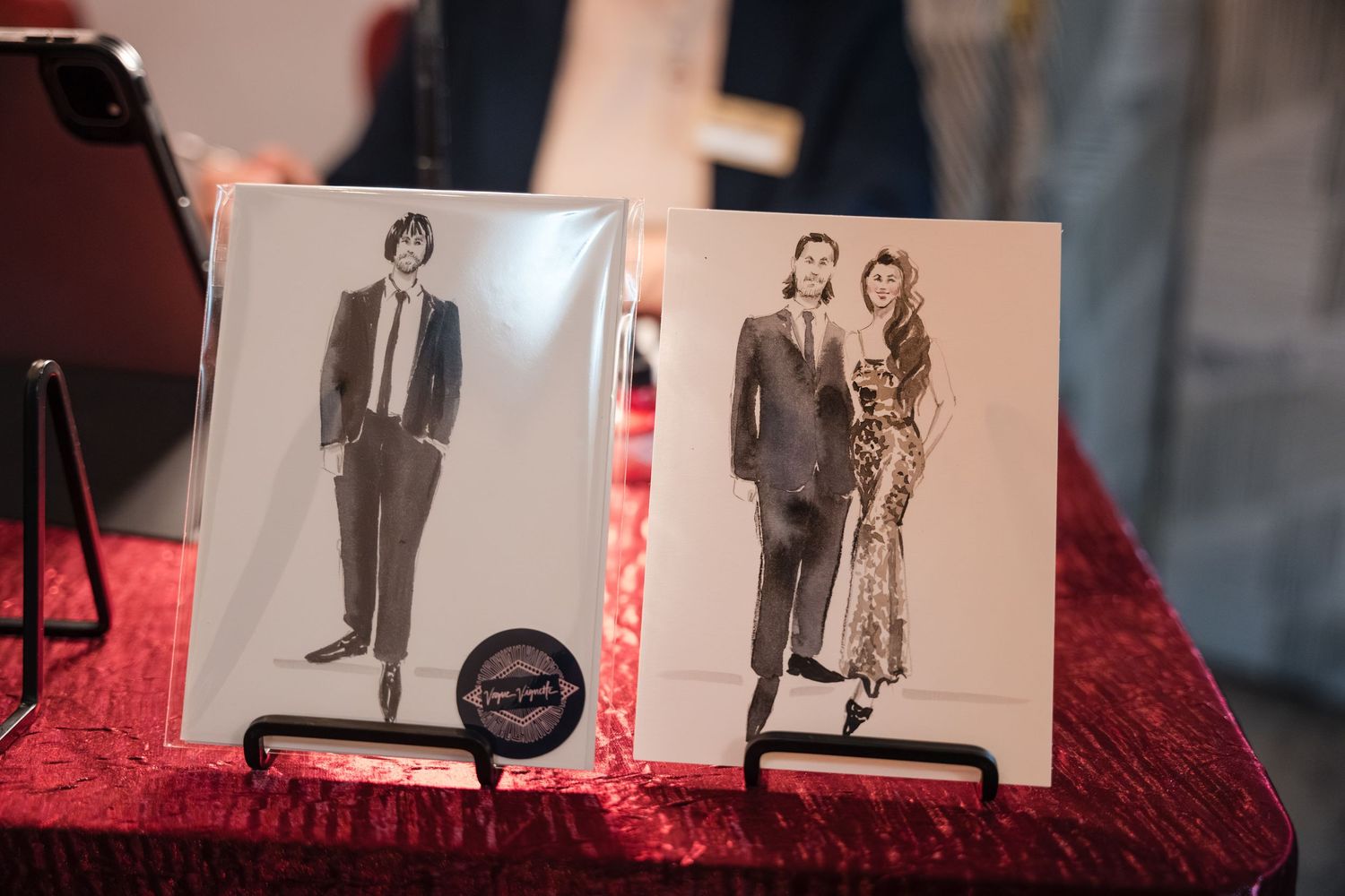 A collection of black and white vintage photographs displayed in a row on a red velvet surface.