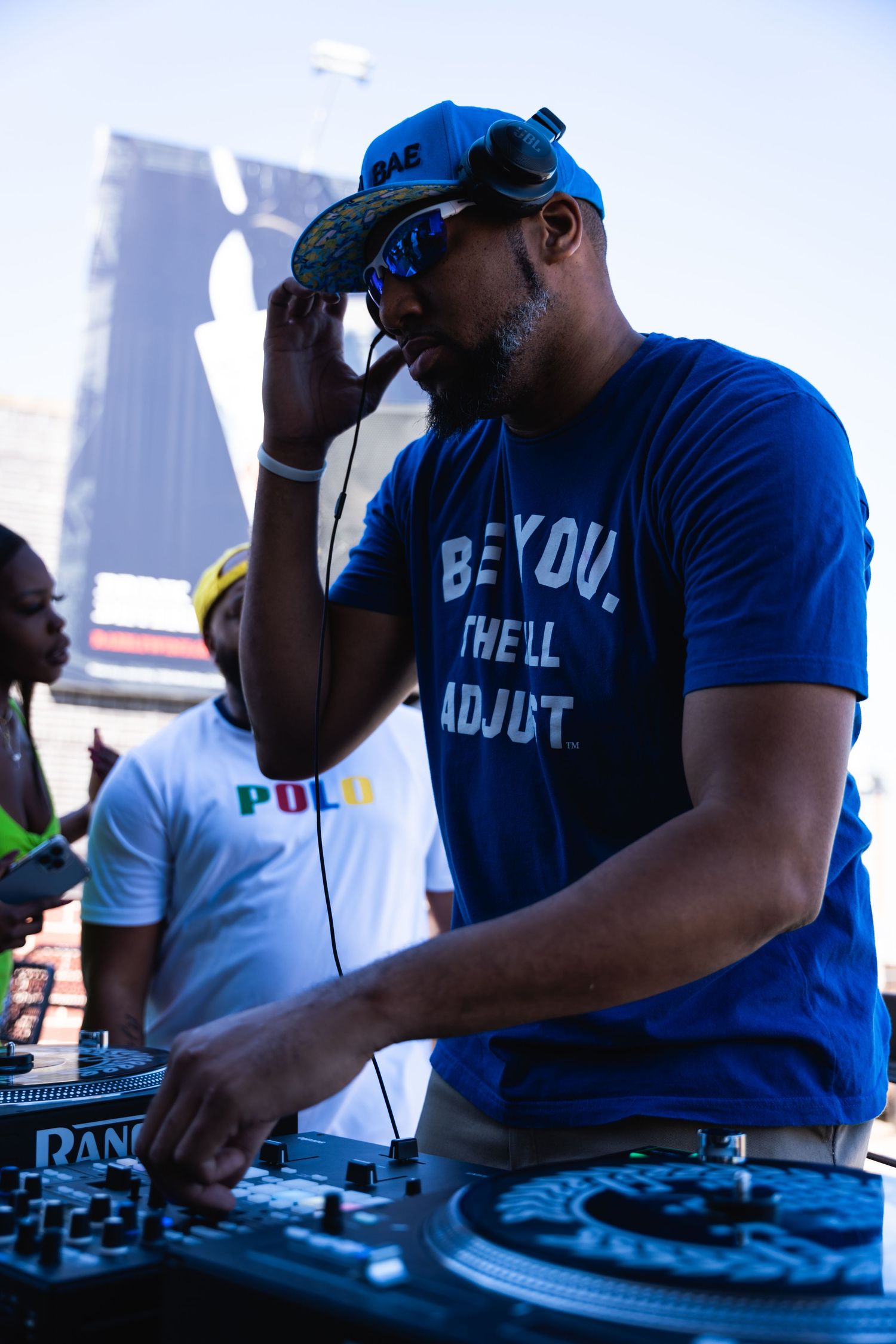 DJ performing at an outdoor event with mixing equipment.