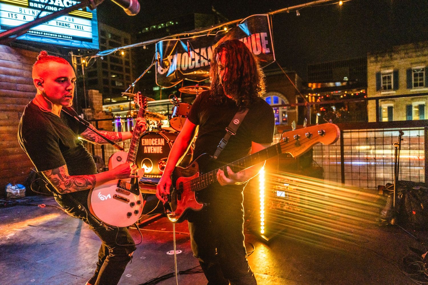 Rock guitarists performing on stage with dramatic lighting and smoke effects.