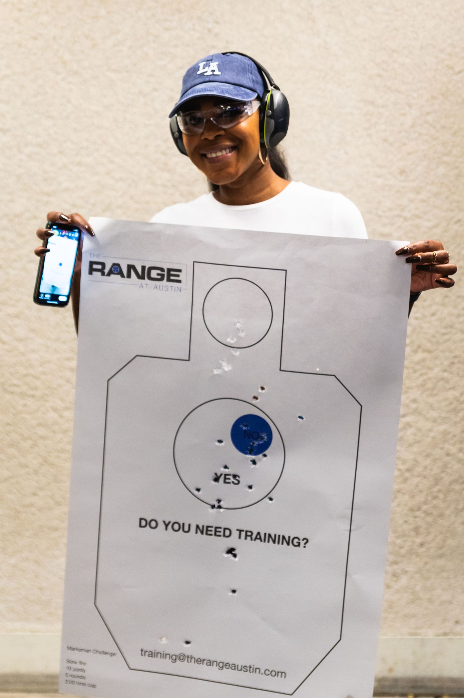 Person holding target practice sheet showing shooting accuracy at indoor range.