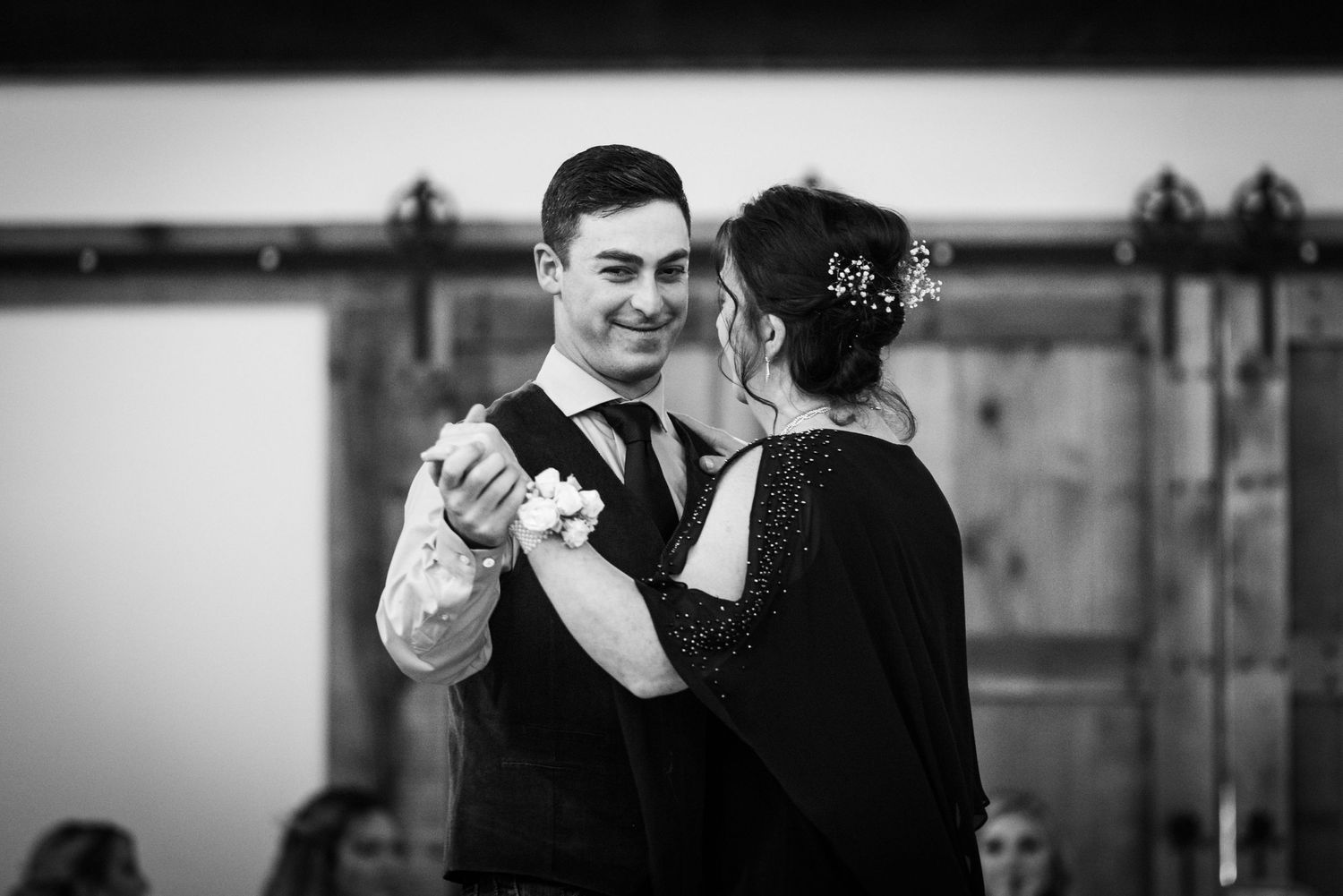 Black and white photo of elegant couple sharing dance at wedding reception.