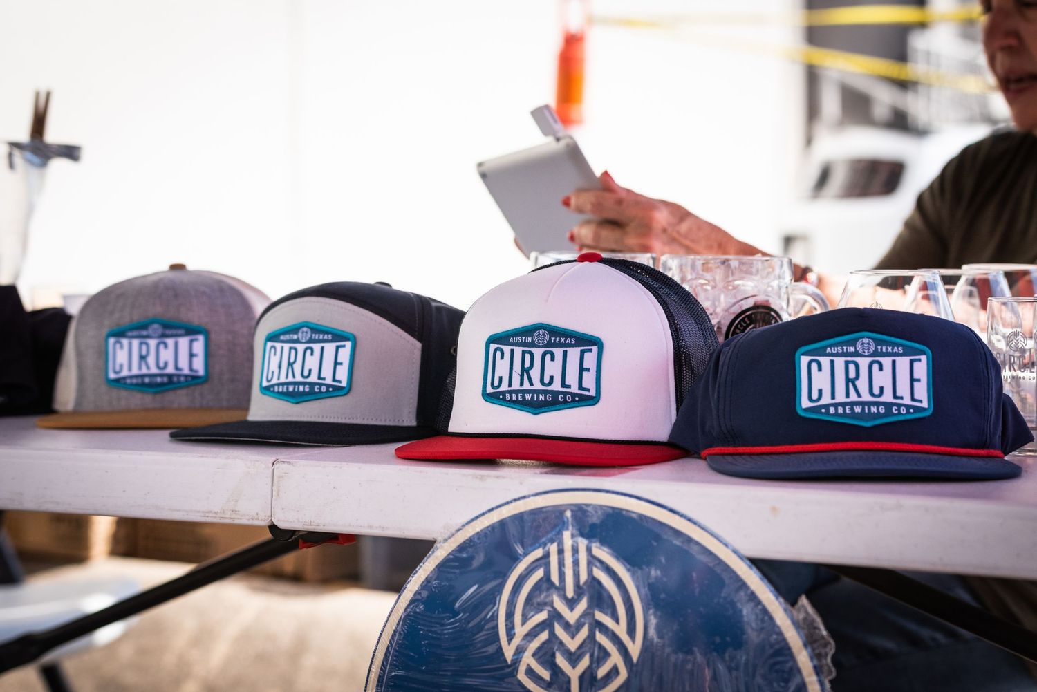 Display of Circle Brewing Company trucker hats with blue and white logo designs.