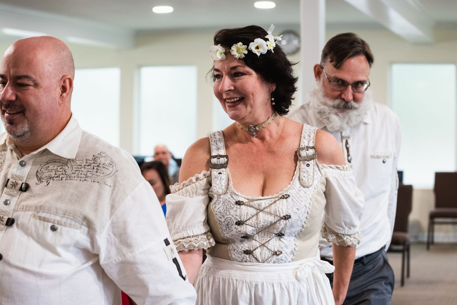 Wedding celebration in traditional German dirndl and folk attire with joyful expressions.