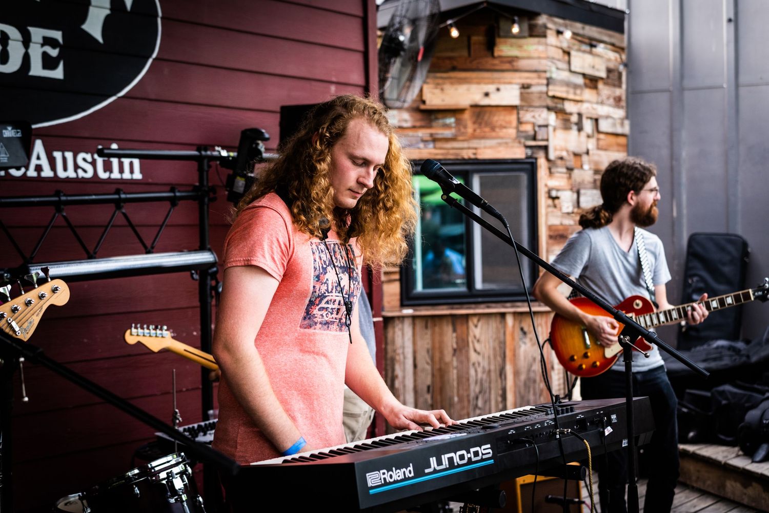 Musicians perform on stage at Crab Pride in Austin with a keyboard player and guitarist playing live music.