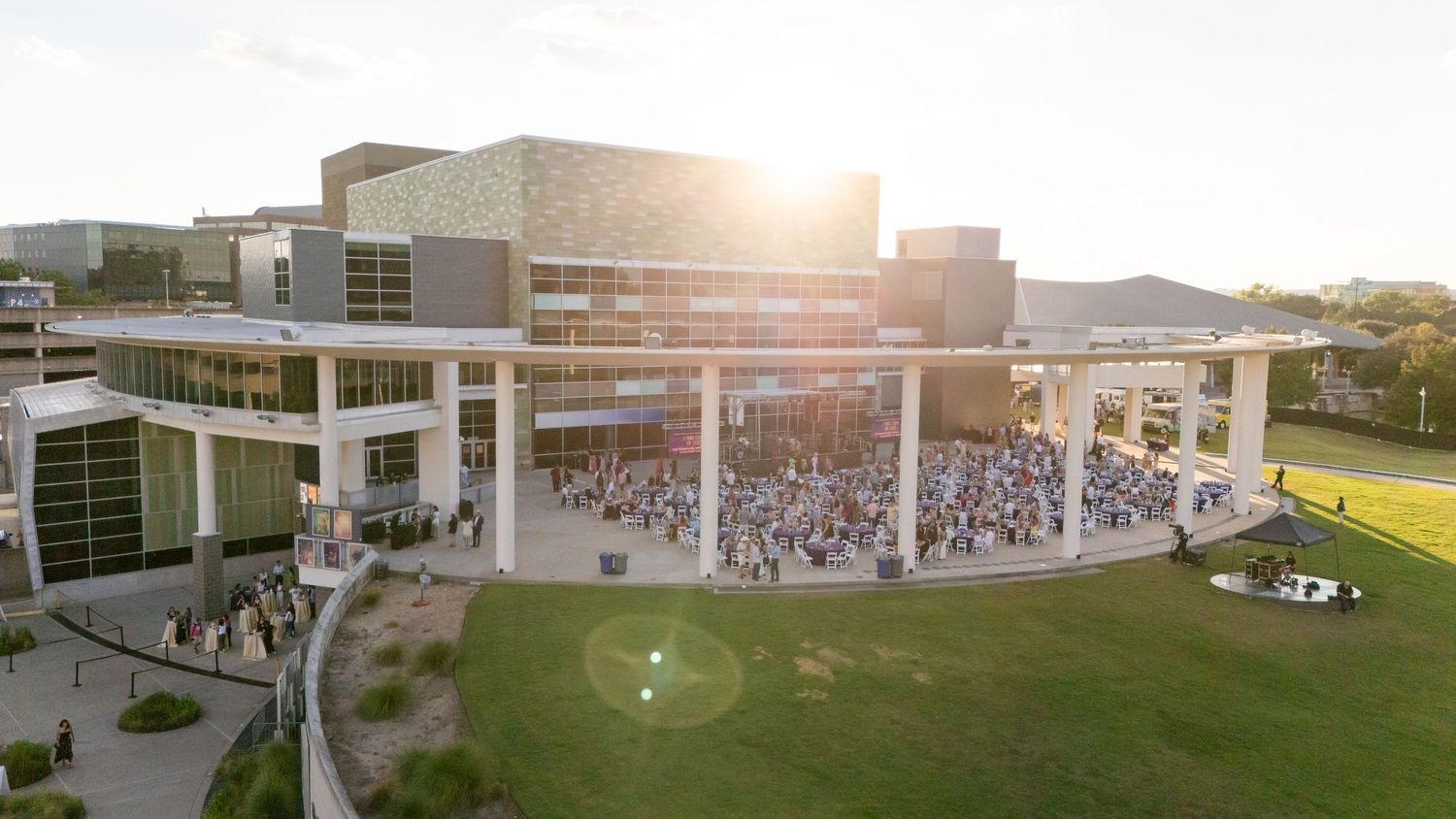 Drone shot of outdoor amphitheater venue with large crowd gathered at dusk.