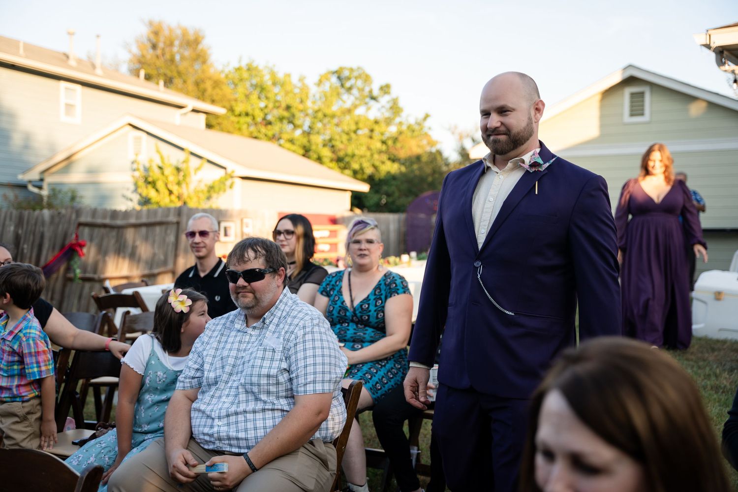 Guests seated outdoors at a backyard event during golden hour.