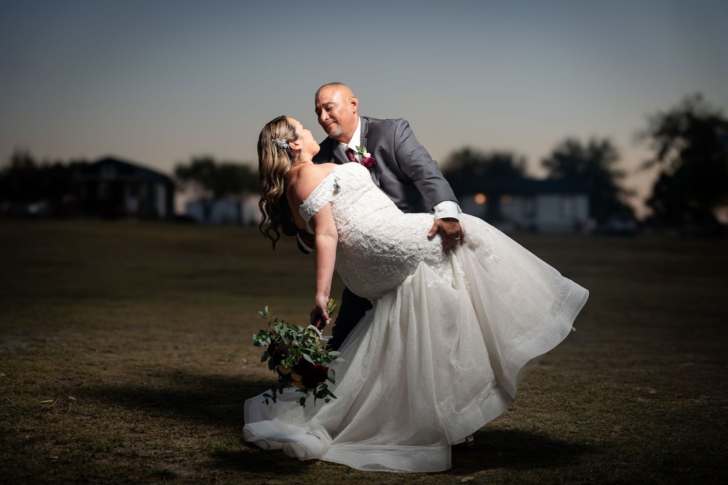 Dramatic sunset wedding portrait with couple in an outdoor setting.