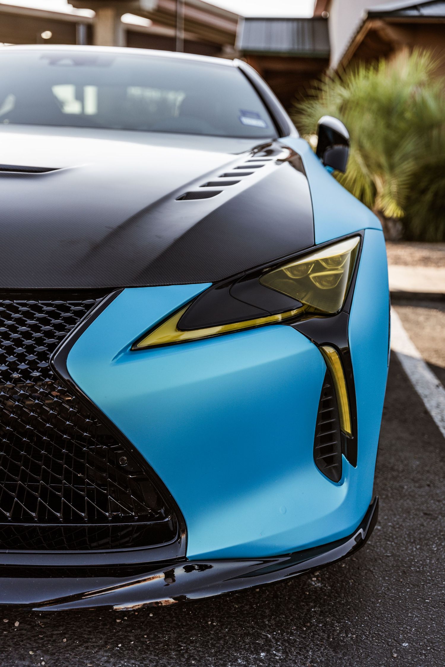 Close-up of a black and blue Lexus LC500's front headlight and grille design.