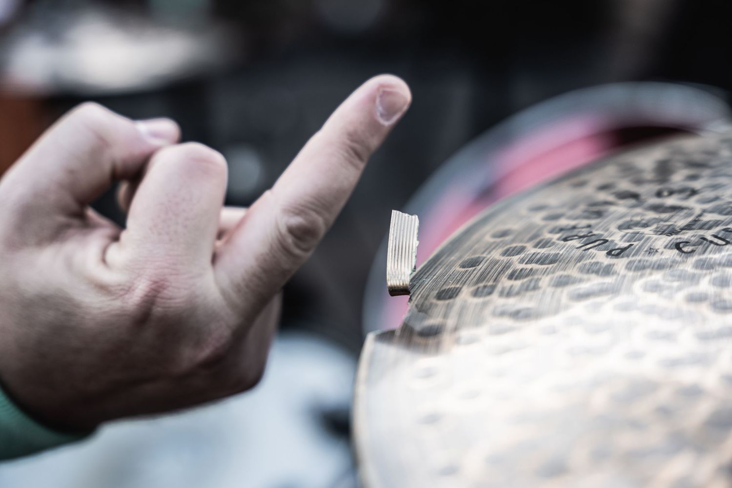Close-up shot of hand tapping cymbal during musical performance.