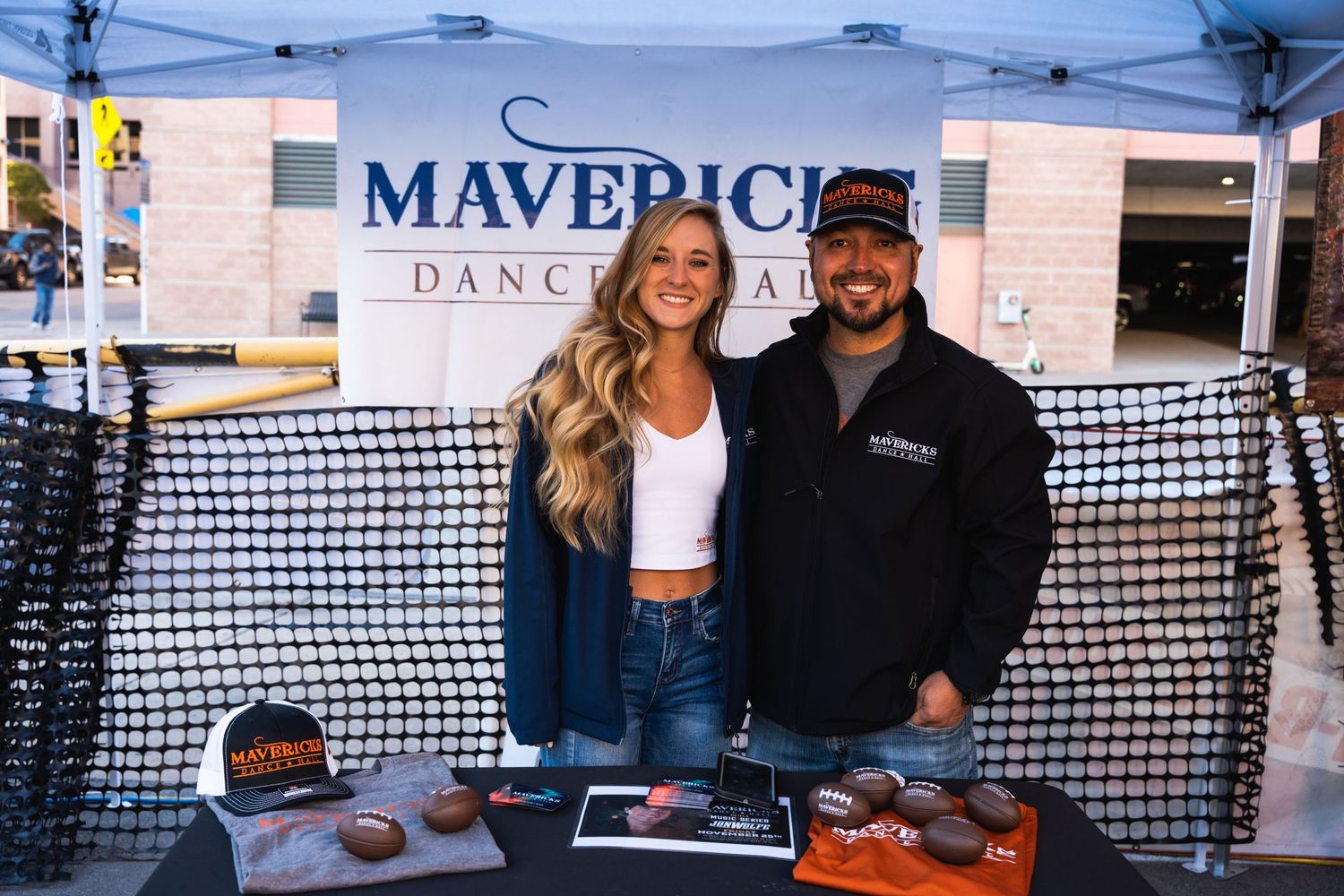 Brand display booth with Maverick Dance Hall banner and staff at event.