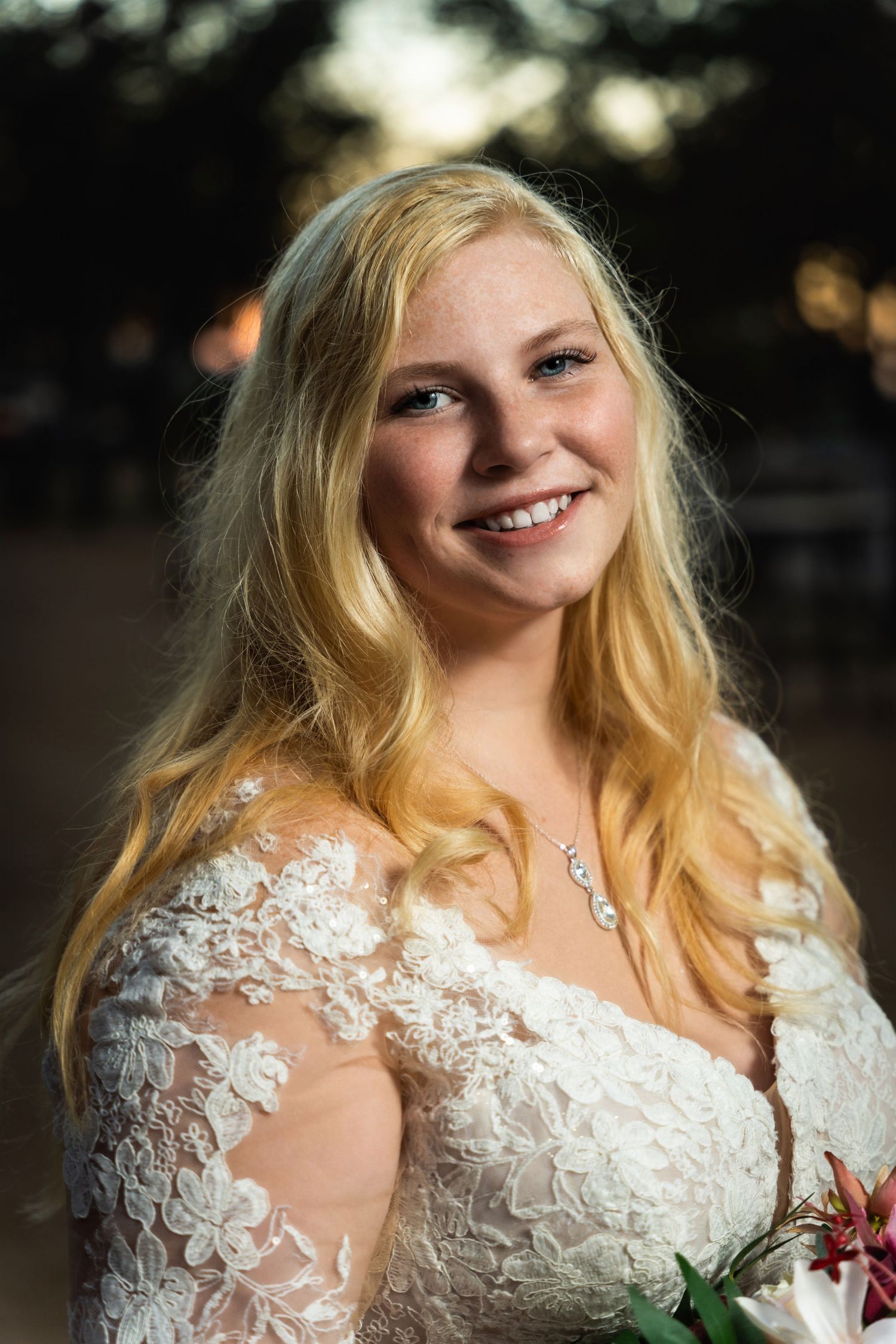 Romantic sunset bridal portrait with lace dress details.