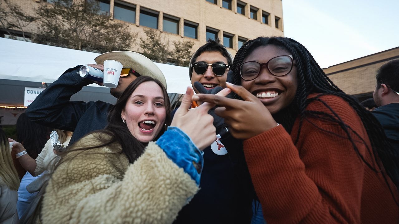 Friends celebrating together at an outdoor event with enthusiastic expressions.