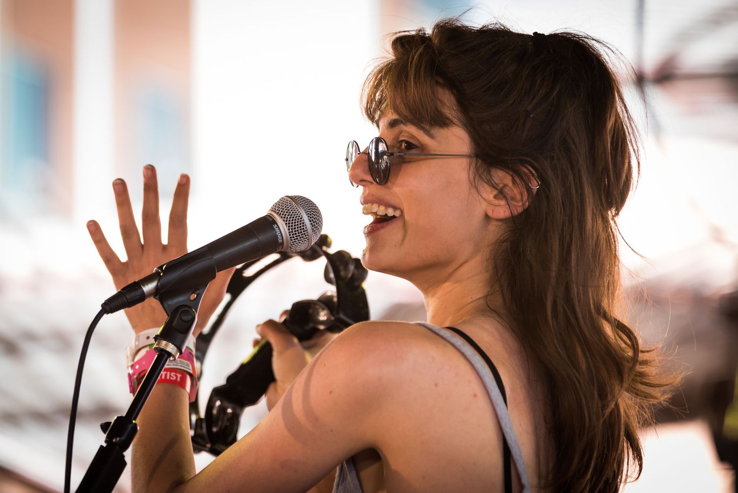 A singer performs passionately on stage with a microphone while wearing sunglasses and dark clothing.