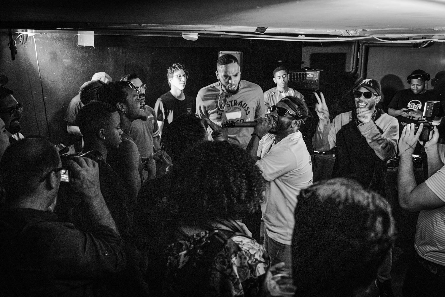 A crowded nightclub scene with people dancing and socializing in a dimly lit space.