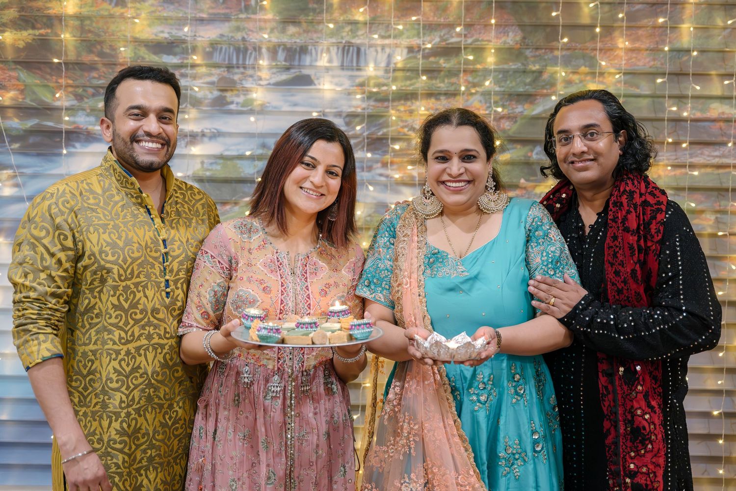Family members in coordinated outfits pose together against a sparkly backdrop for festive portraits.