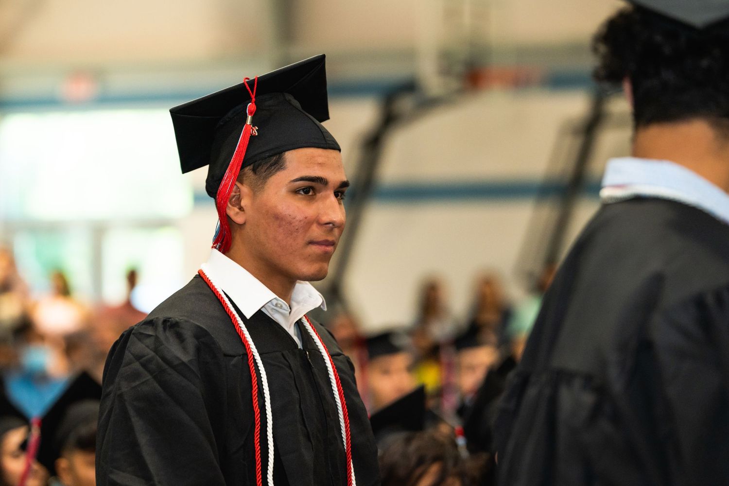 Graduate in black cap and gown at commencement ceremony.