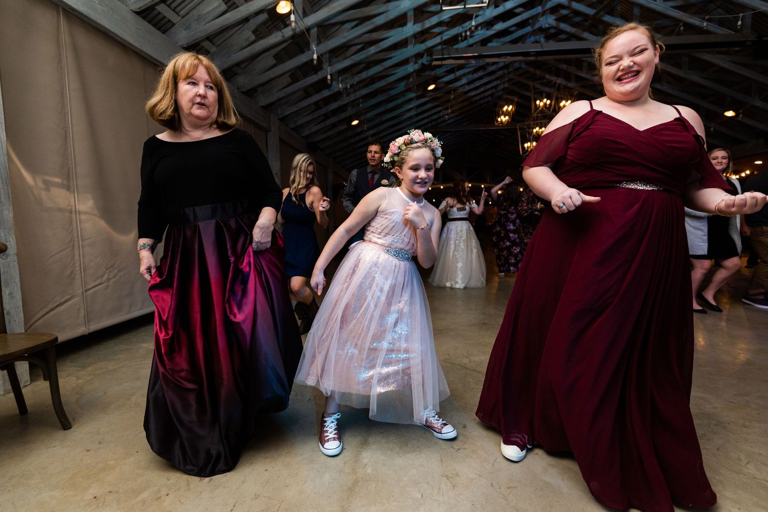 Wedding guests dancing and enjoying themselves at an indoor reception venue.
