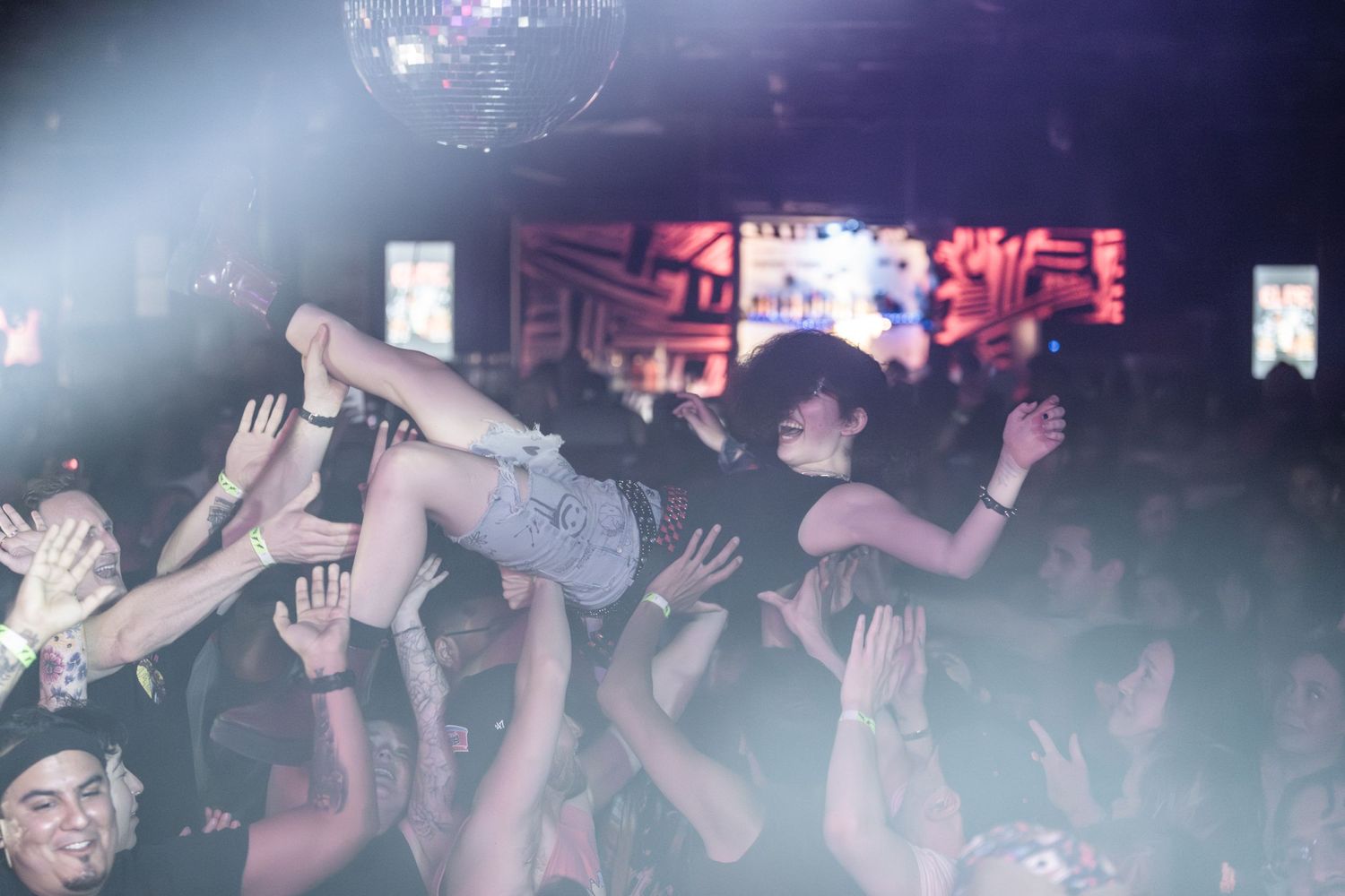 Concert crowd surfing during energetic live music performance.