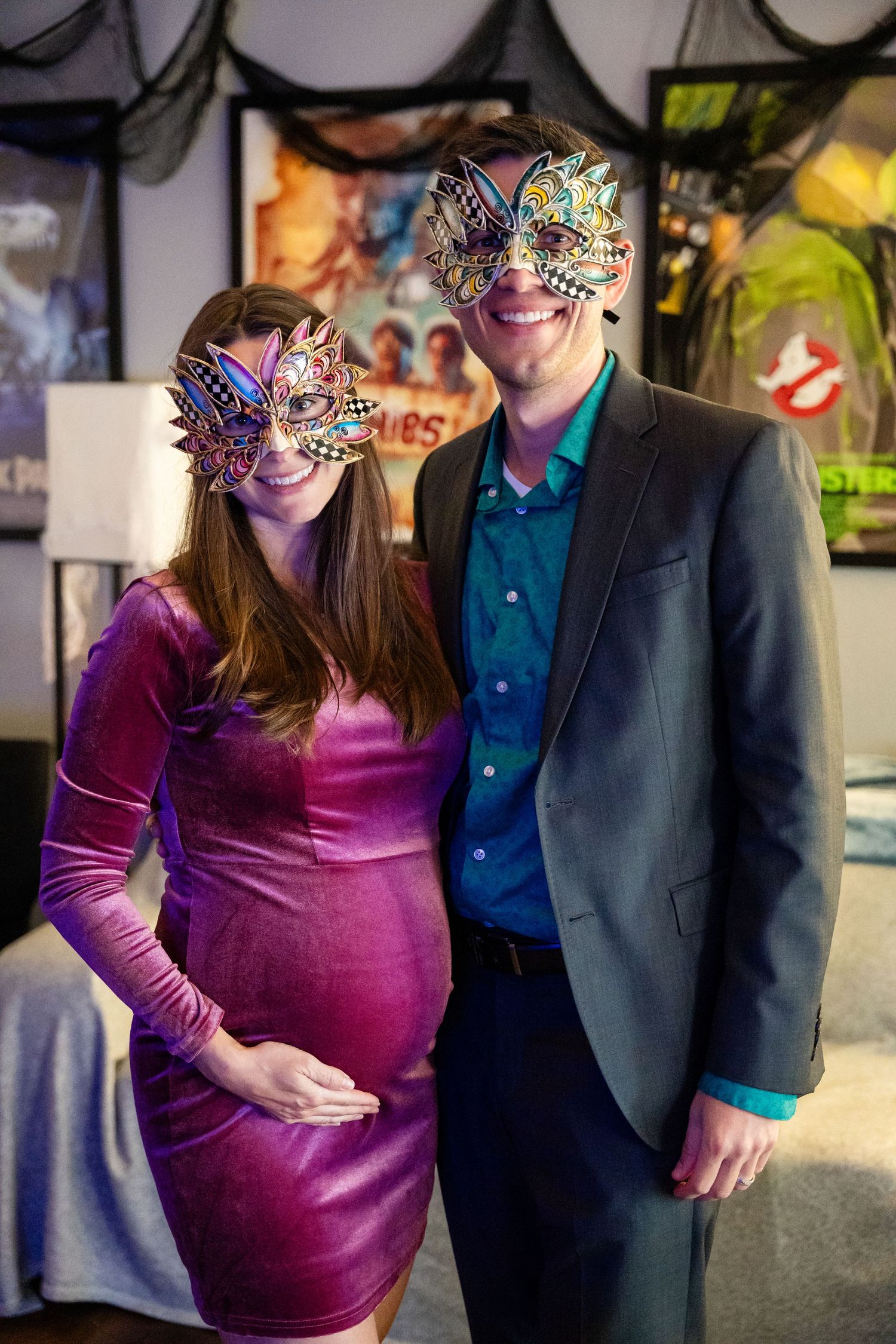 Couple in formal attire wearing ornate masquerade masks at a themed celebration.