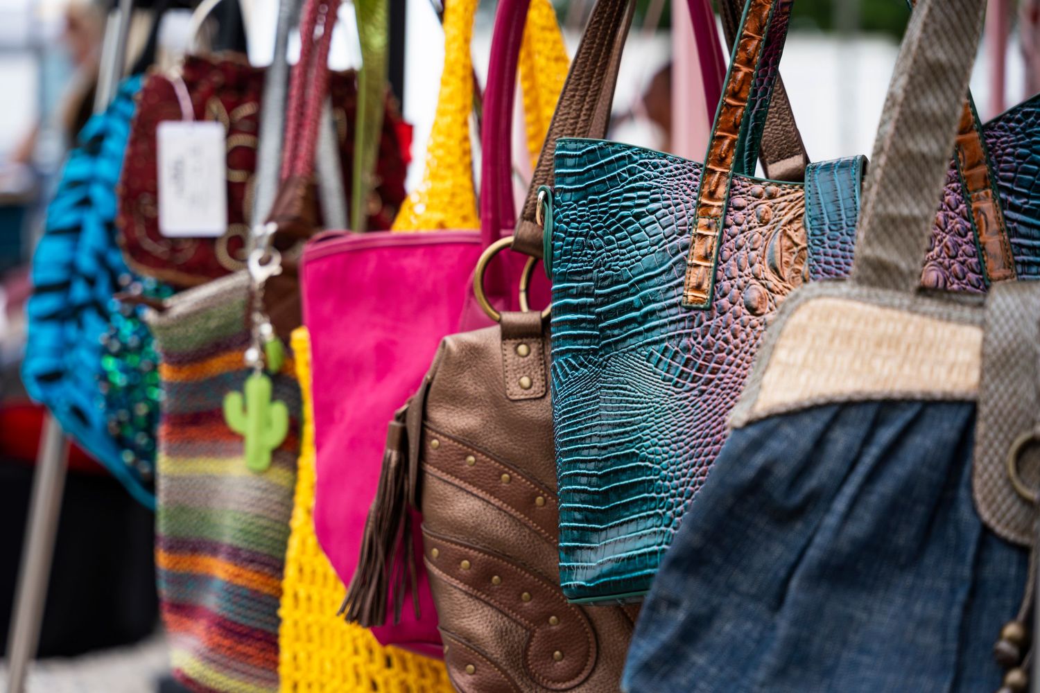 Colorful collection of handcrafted Mexican leather handbags and purses displayed at a market.