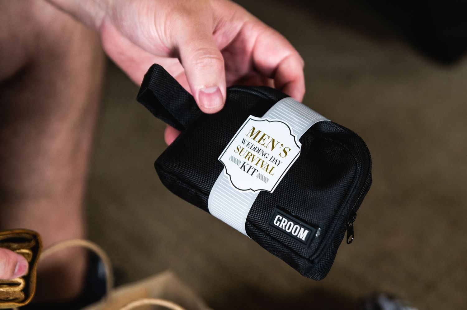 Hands holding a black camera strap with a custom label.