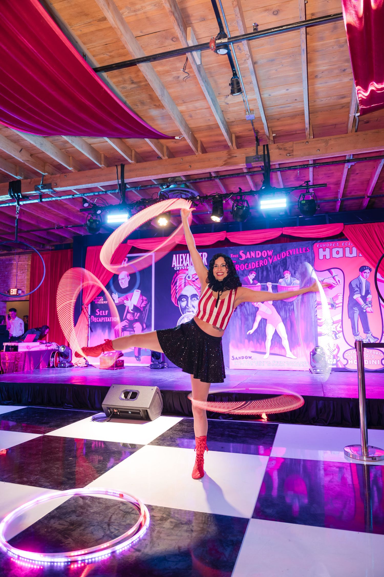 A colorful indoor skating rink with pink neon lighting and artistic wall murals creates an energetic atmosphere for skaters.
