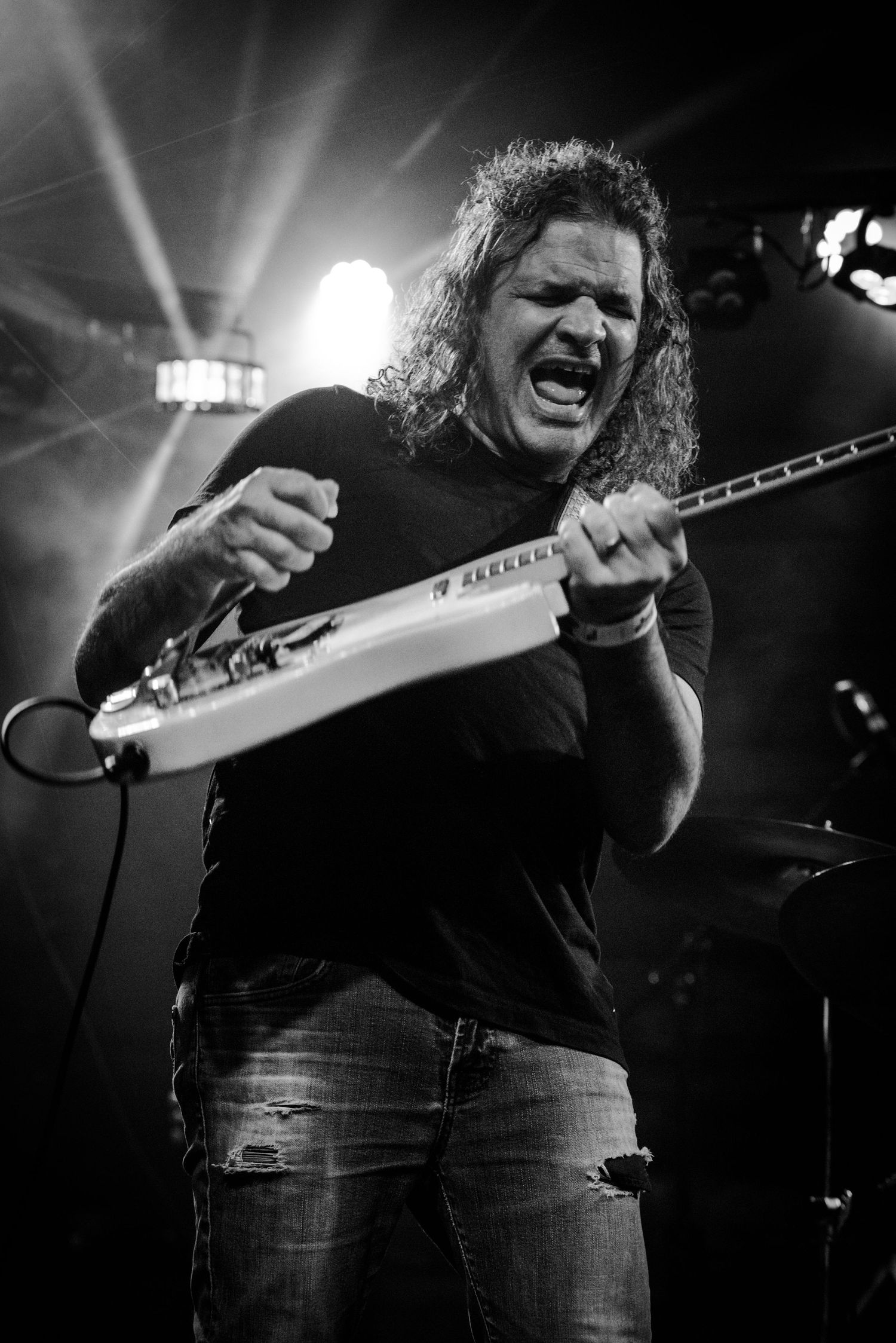 A black and white photo sequence shows an energetic performer singing passionately on stage during a concert.