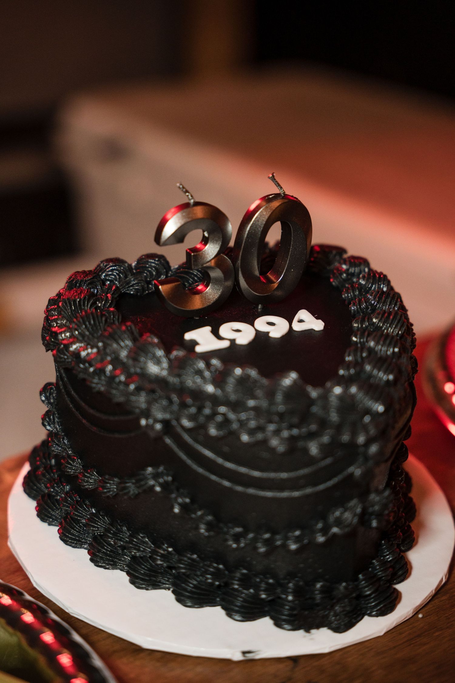 A series of chocolate Oreo cakes with dark frosting and decorative piping shown from different angles on a wooden surface.