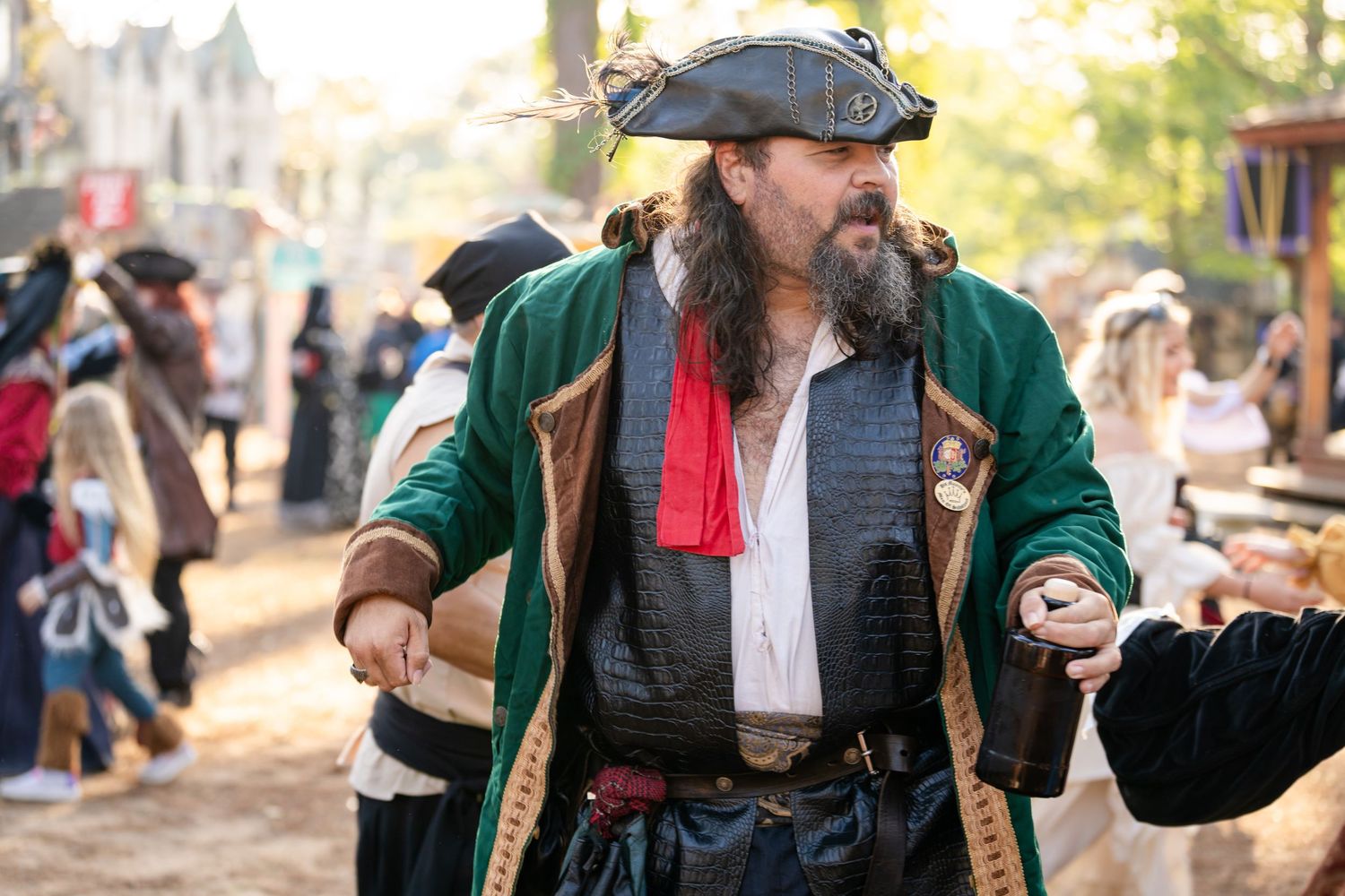 A person in medieval or renaissance period costume performs at an outdoor festival with dramatic lighting.