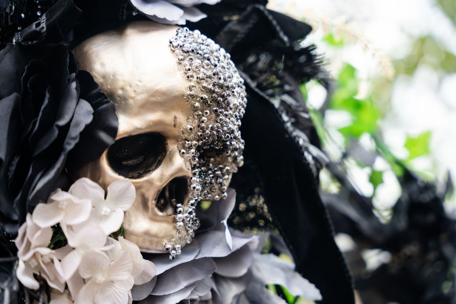 Decorative skull adorned with crystals and floral arrangements in a gothic style.