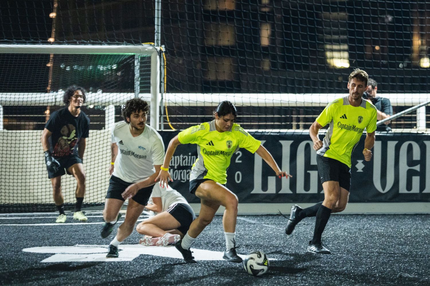 Players in yellow and white jerseys compete for the ball during an intense indoor match.