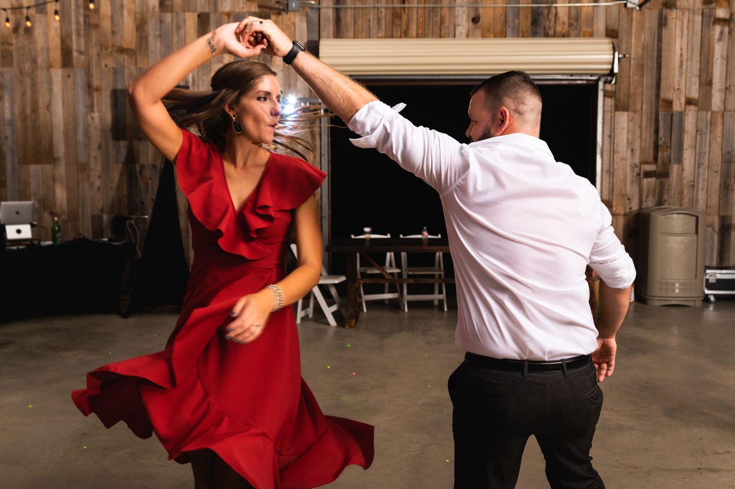 Dancing couple performs a dramatic spin move as the red dress flows with the movement.