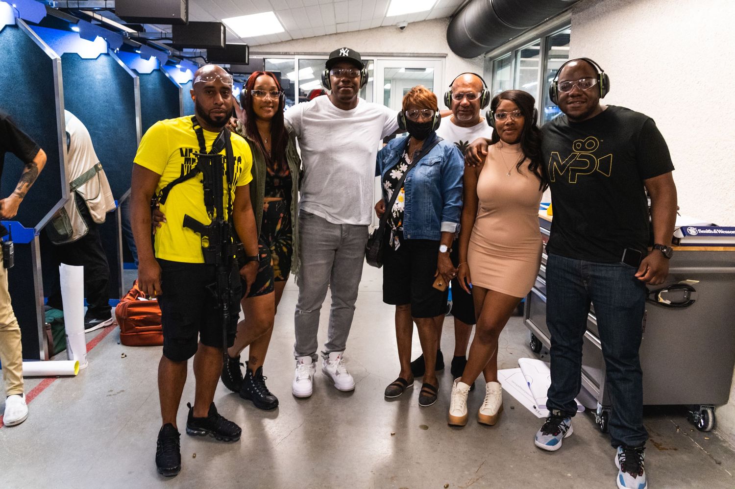 A group poses together for a photo in what appears to be a backstage or storage area.
