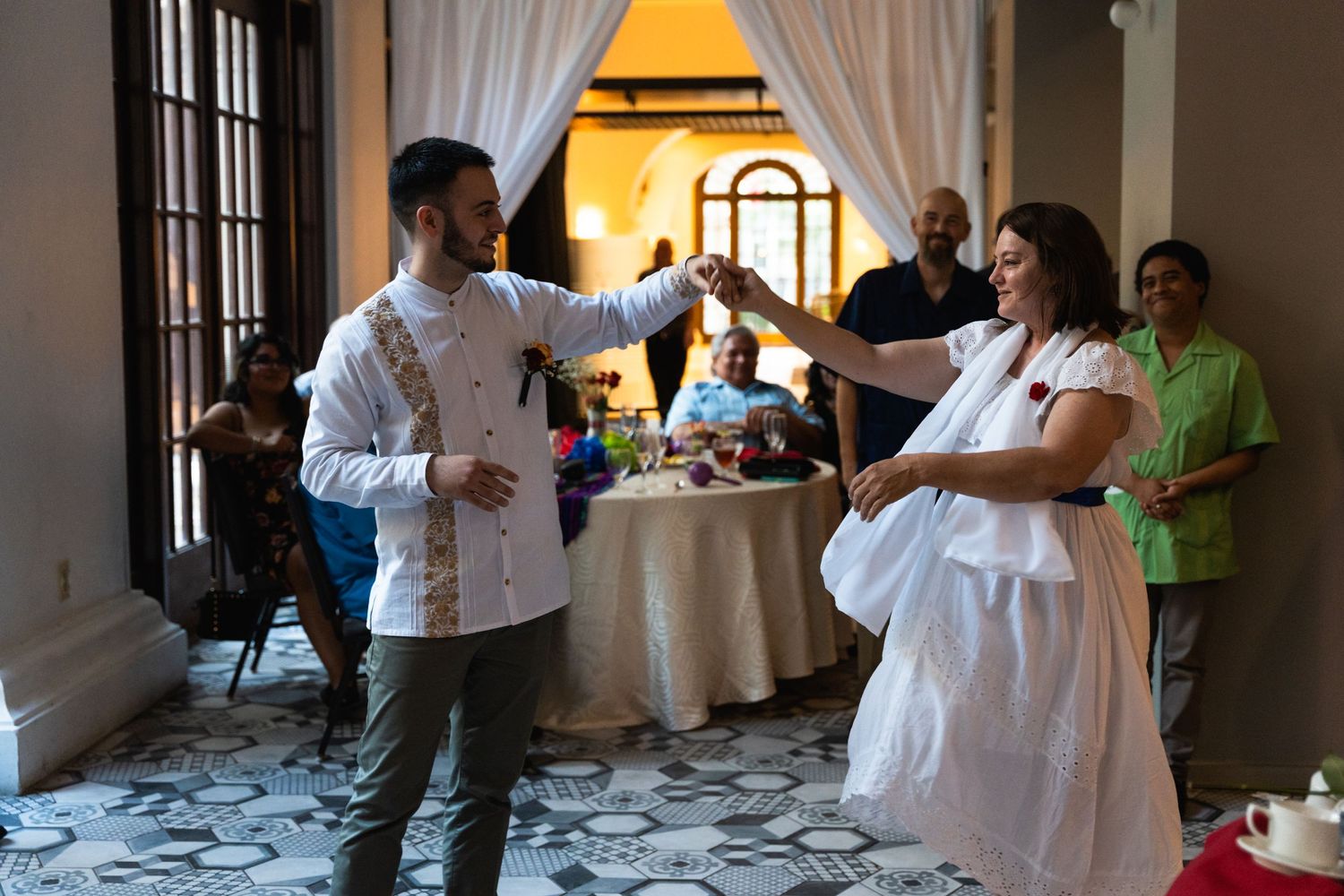 Wedding reception guests enjoying casual moment in elegant venue.