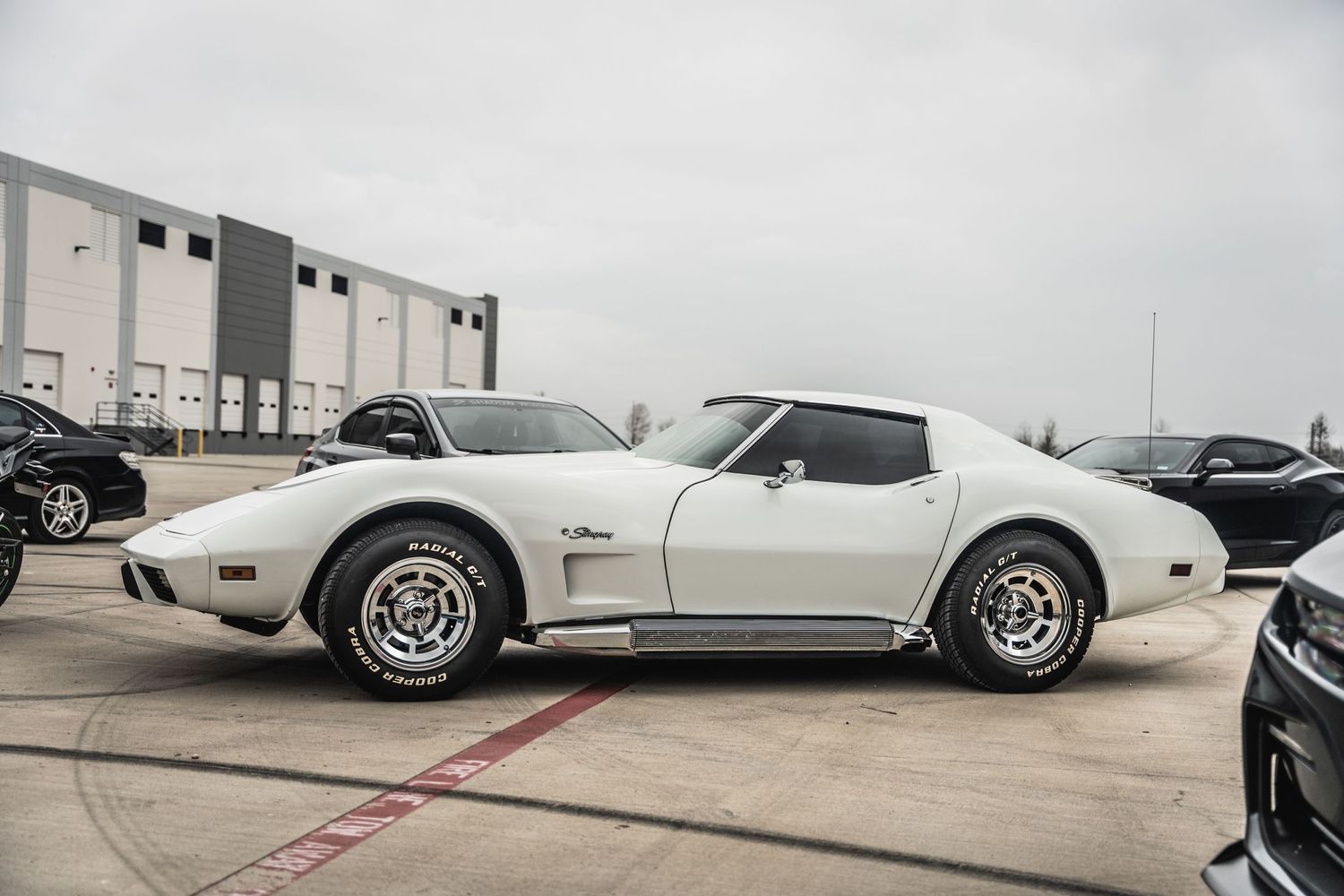 Classic white Chevrolet Corvette C3 Stingray parked in outdoor lot.