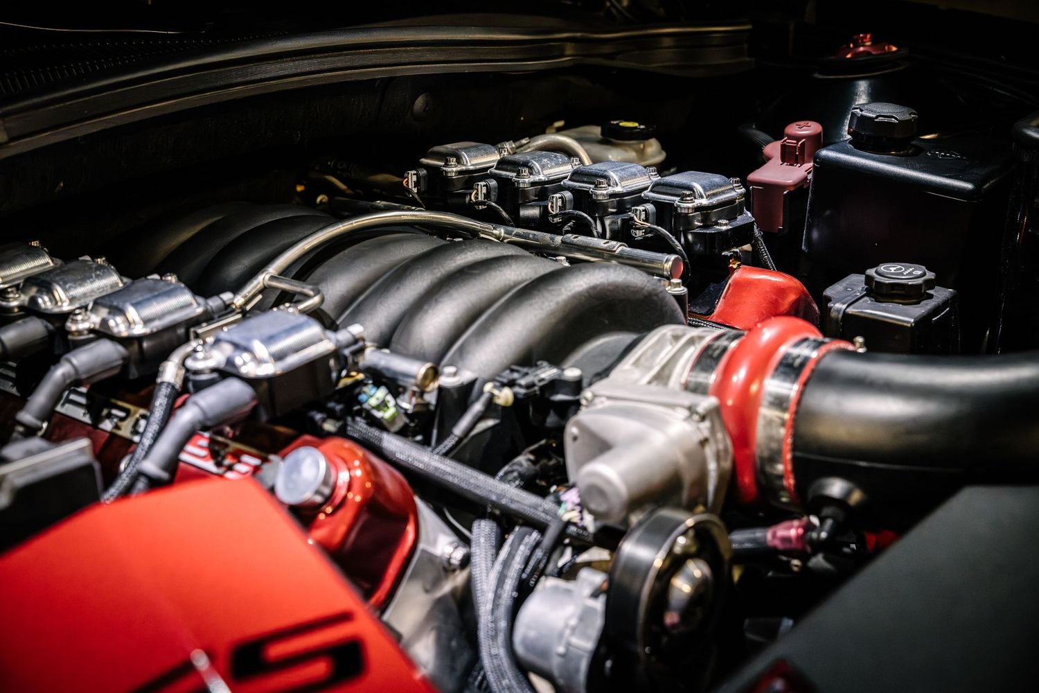 Detailed view of a modified performance engine bay showing intake manifold and red components.