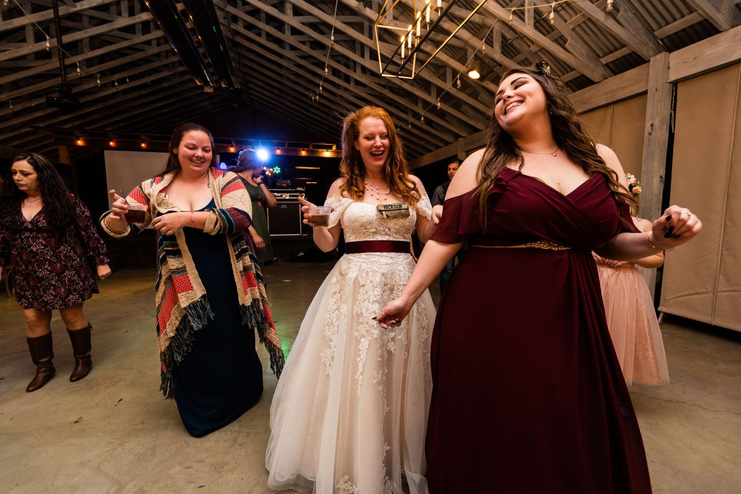 Wedding guests in formal attire dancing and celebrating at a reception venue.