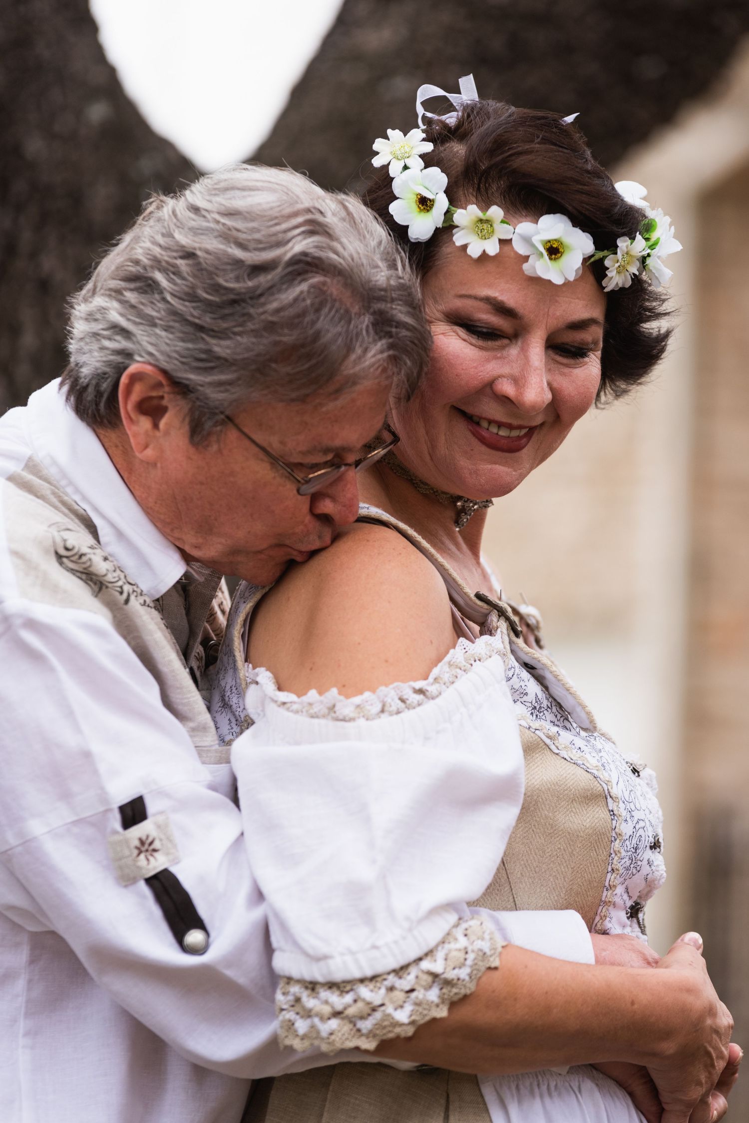 A romantic embrace captured outdoors with delicate floral crown details.