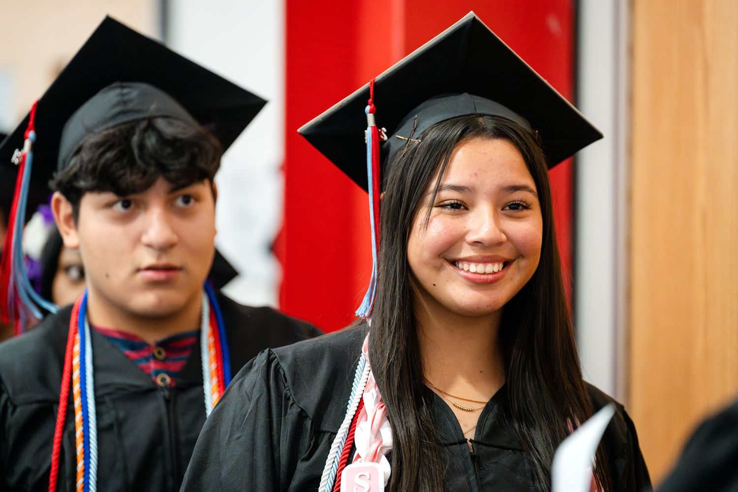 Graduates in traditional black academic regalia at commencement ceremony.