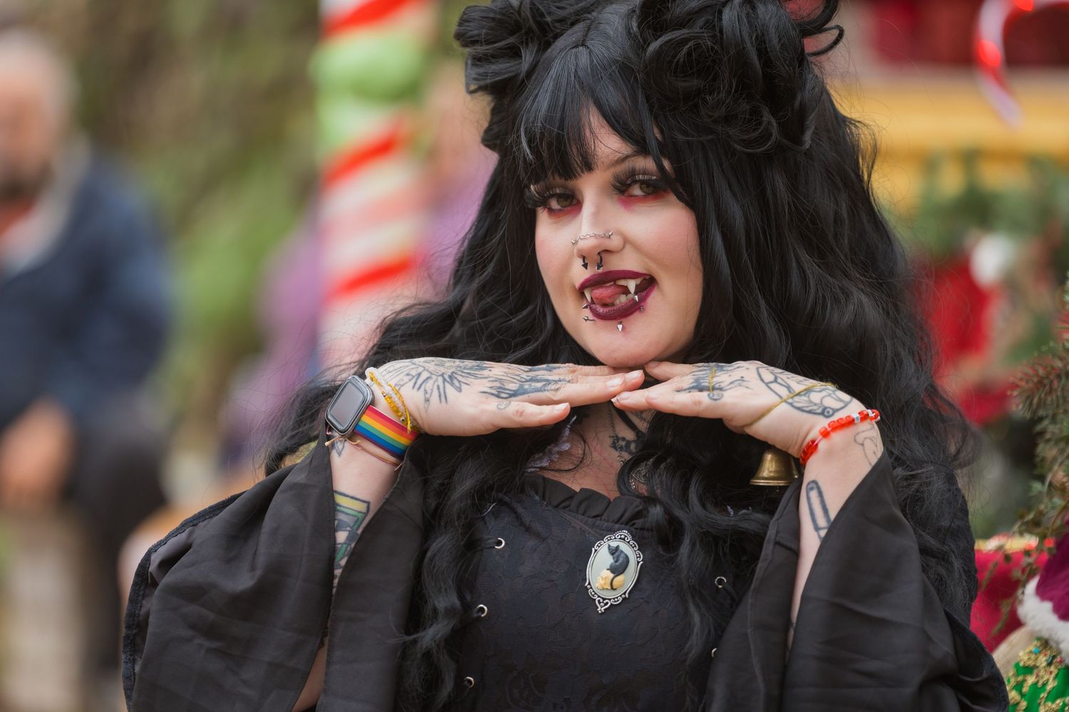 Gothic-styled performer in black dress poses dramatically at festival.
